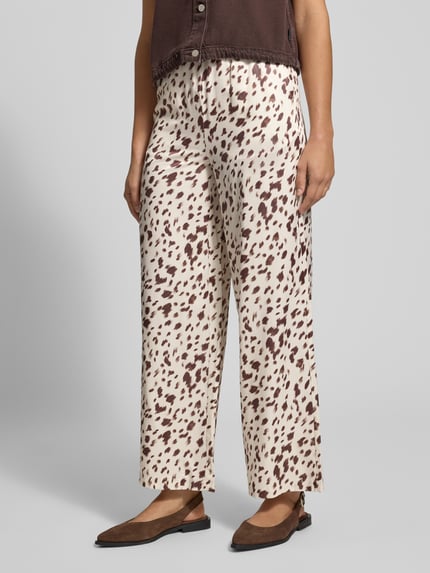 Frauenmodel trägt Stoffhose aus Viskose-Mix mit elastischem Bund Modell 'Verde' von OH APRIL, Creme mit braunem Muster, Wide Fit, Nahaufnahme Unterkörper, Damen Stoffhose, Größe S, Bundweite 33 cm, Innenbeinlänge 74 cm.