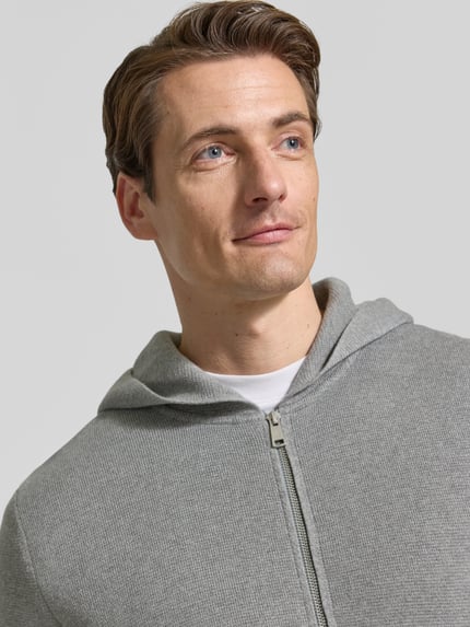 Männermodel trägt Regular Fit Pullover aus reiner Baumwolle von Marc O'Polo in Hellgrau mit feiner Struktur, Nahaufnahme Oberkörper.