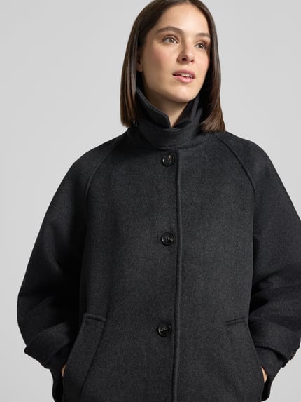 Frauenmodel trägt Mantel aus Leinen-Mix mit Stehkragen Modell 'Keaton' von Neo Noir, dunkel, mittlere Struktur, Nahaufnahme Oberkörper.