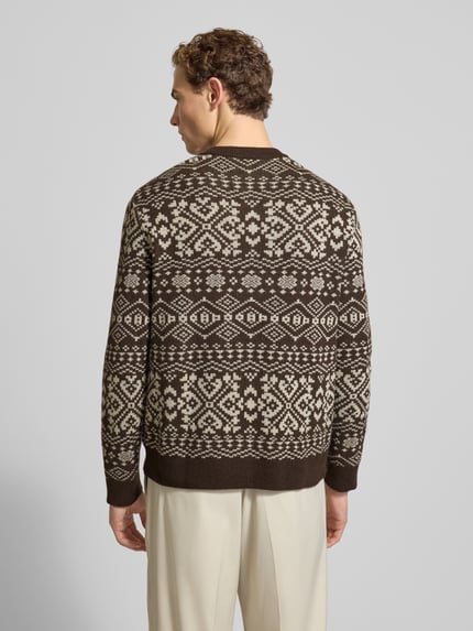 Männermodel trägt Regular Fit Strickpullover aus Woll-Mix Modell 'HOLGER' von SELECTED HOMME mit Jacquardmuster in Braun-Beige, Rippbündchen, Ganzkörperansicht Rückansicht.