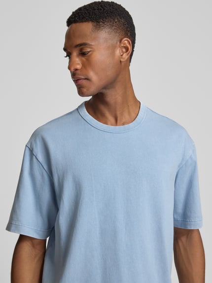 Männermodel trägt Cropped T-Shirt mit Rundhalsausschnitt von GAP in Hellblau, reine Baumwolle, Nahaufnahme Oberkörper.