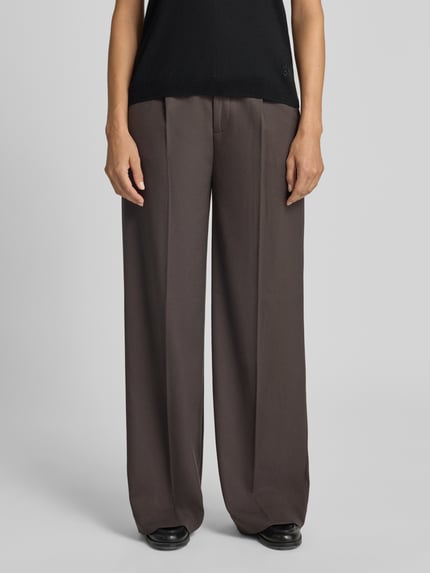Frauenmodel trägt Relaxed Fit Anzughose mit Viskose-Anteil Modell 'TAILOR' von Cph Muse, braun, weites Bein, Kellerfalten, Ganzkörperansicht von vorne.