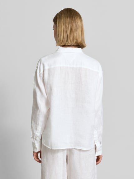Männermodel trägt Oversize Bluse aus reinem Leinen von Tommy Hilfiger, biała, lniana tkanina, długi rękaw, krój oversize, jednolita, logo, widok całej sylwetki z tyłu