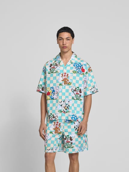 Męski model nosi Freizeithemd mit Allover-Motiv-Print od Kenzo, bawełna, krój relaxed fit, motyw na całej powierzchni, kołnierz rewersowy, krótki rękaw, długość tyłu w rozmiarze M: 74 cm, szerokość ramion w rozmiarze M: 56 cm, długość rękawa w rozmiarze M: 28 cm, jasnoniebiesko-biała kratka z kolorowym nadrukiem, widok całej sylwetki z przodu