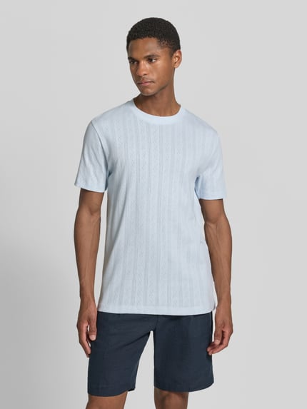 Männermodel trägt T-Shirt in Jaquard-Strick mit Rundhalsausschnitt von Lindbergh in Hellblau, Regular-Fit, Reine Baumwolle, Label-Detail, Rückenlänge bei Größe M 72 cm, Ganzkörperansicht von vorne.