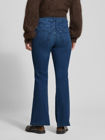 Frauenmodel trägt Flared Jeans mit Knopfverschluss von Christian Berg Woman, dunkelblaue Baumwoll-Mix-Jeans mit Stretch, Flared Cut, 5-Pocket-Design, Rückansicht Ganzkörperansicht.