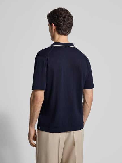Männermodel trägt Regular Fit Poloshirt aus Baumwolle von CRUNA in Dunkelblau mit Polokragen und Strick-Optik, Ganzkörperansicht Rückansicht.