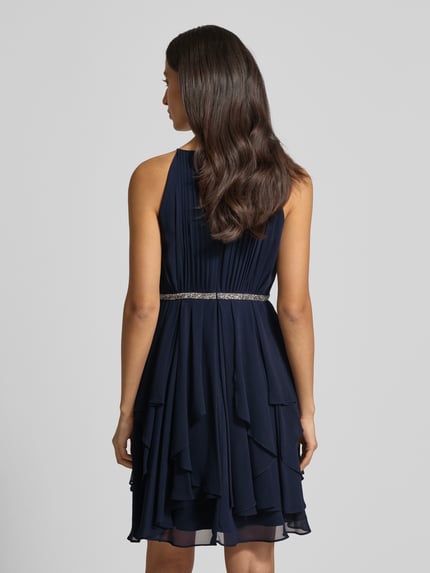 Frauenmodel trägt Cocktailkleid mit Nahtreißverschluss von Jake*s Cocktail in Dunkelblau, taillierter Schnitt, blickdichtes Unterkleid, Rückenlänge 92 cm, Brustweite 33 cm, Ganzkörperansicht Rückansicht.