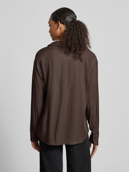 Frauenmodel trägt Relaxed Fit Langarmbluse aus reiner Viskose Modell 'LARISAANA' von ARMEDANGELS in Dunkelbraun, fließende Textur, Ganzkörperansicht Rückansicht.