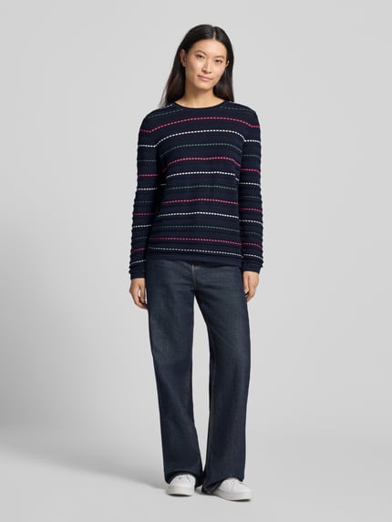Frauenmodel trägt Strickpullover mit Struktur-Muster von Christian Berg Woman in Dunkelblau mit bunten Streifen, Rundhalsausschnitt, reine Baumwolle, gerader Schnitt, kombinierbar mit Jeans und Sneakern, Ganzkörperansicht von vorne.