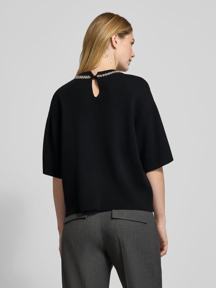 Frauenmodel trägt Strickshirt mit Ziersteinbesatz Modell 'DORISE' von ICHI, schwarz, Relaxed Fit, Viskose-Mix, Ganzkörperansicht Rückansicht.