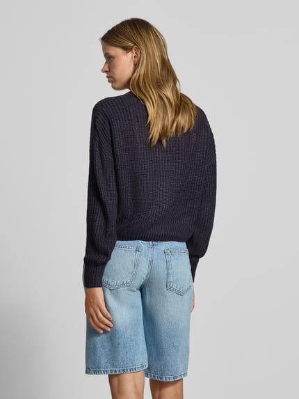 Frauenmodel trägt Boxy Fit Strickjacke mit V-Ausschnitt Modell 'CAROL' von ONLY in Dunkelblau mit Strickstruktur, Damen Strickjacke von ONLY, Ganzkörperansicht Rückansicht.