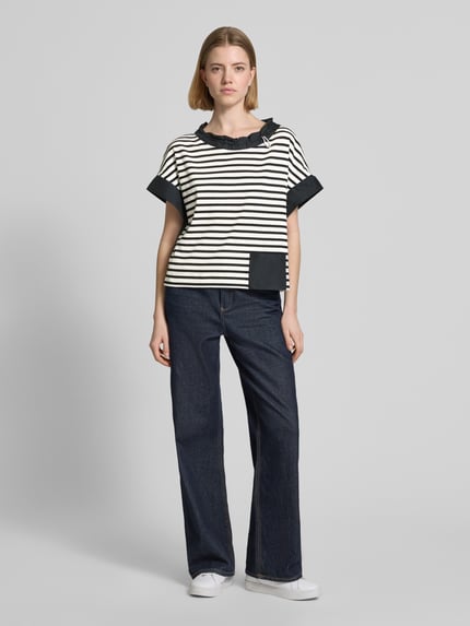 Frauenmodel trägt T-Shirt mit Rundhalsausschnitt und Kordelzug von Marc Cain, schwarz-weiß gestreift, Eingrifftasche, gerader Schnitt, Ganzkörperansicht von vorne.