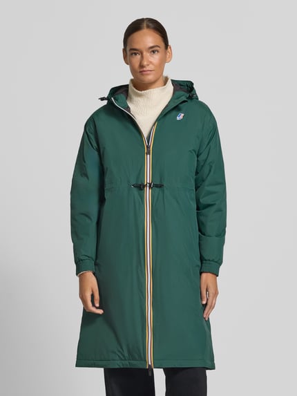 Frauenmodel trägt Regular Fit Mantel mit Logo-Print Modell 'DELIA' von K-WAY in Dunkelgrün, Kapuze mit Tunnelzug, wasserabweisend, Ganzkörperansicht von vorne.