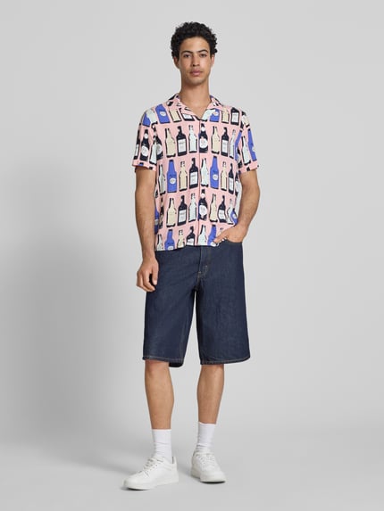 Männermodel trägt Regular Fit Freizeithemd aus Viskose Modell 'ANVAR' von Blend mit Allover-Print, Reverskragen, Ganzkörperansicht von vorne.