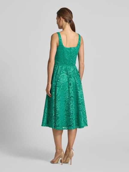 Vrouwenmodel draagt knielanges Kleid met Allover-Spitzen-Besatz van Rinascimento in groen, tailleer- en uitlopend fit, elastische mix, afneembare riem, geheel kanten look, mouwloos, detailopname rugaanzicht.