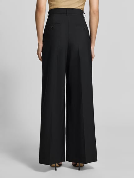 Frauenmodel trägt Regular Fit Weite Hose aus reiner Schurwolle Modell 'OVVIO' von Weekend Max Mara in Schwarz mit glatter Struktur, Ganzkörperansicht Rückansicht. Damen Weite Hose von Weekend Max Mara.