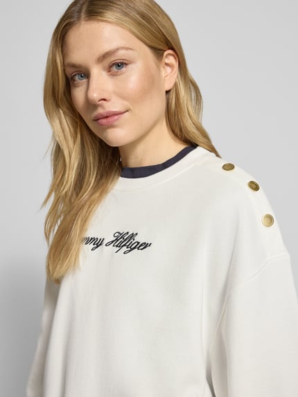 Vrouwenmodel draagt Relaxed Fit Sweatshirt uit katoenmix van Tommy Hilfiger, effen wit met labelstiksel, geribde randen, Nahaufnahme bovenlichaam.