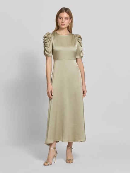 Frauenmodel trägt Cocktailkleid aus Satin mit Puffärmeln Modell 'Benuti Solid' von Neo Noir in A-Linie als Maxikleid, sanfte Glanzoptik, dezente beige Farbe, Rückenlänge bei Größe 36: 136 cm, Brustweite 42 cm, Ärmellänge 33 cm, Ganzkörperansicht von vorne.