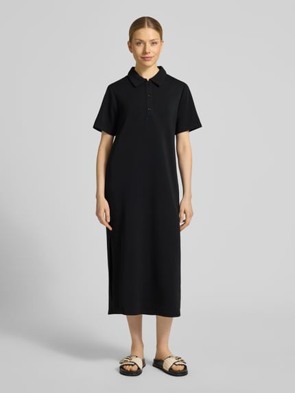 Vrouwenmodel draagt Polokleid met Knopfleiste Modell 'Helle' van My Essential Wardrobe, zwart, rechte fit, midi, viscosemix, voorkant totaalbeeld.