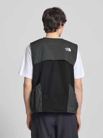 Männermodel trägt Regular Fit Weste mit Logo-Stitching von The North Face, Material-Mix, Schwarz mit Muster, Rückenlänge 63 cm, Ganzkörperansicht Rückansicht.