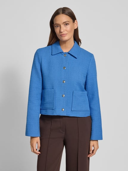 Kobiece model nosi Kurtka Regular Fit z wykładanym kołnierzem Model 'Nilsa' od MOS MOSH z mieszanki bawełny, nakładane kieszenie, listwa guzikowa, brązowe spodnie, tło szare, długość tyłu w rozmiarze 36: 51 cm, szerokość w rozmiarze 36: 52 cm, długość rękawów w rozmiarze 36: 62 cm. Zdjęcie całej sylwetki z przodu.