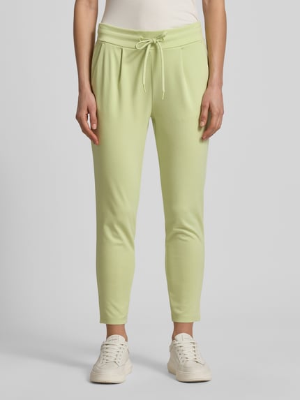 Frauenmodel trägt Sweatpants mit Tunnelzug Modell 'KATE' von ICHI in zartem Grün, Regular-Fit, Material-Mix mit Viskose-Anteil, elastischer Bund, Ganzkörperansicht von vorne.