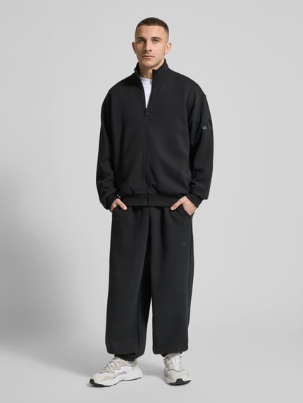Männermodel trägt Loose Fit Sweatjacke mit Modal und Baumwoll-Anteil von adidas Sportswear, Optik: Unifarben, Material-Mix, Ganzkörperansicht von vorne