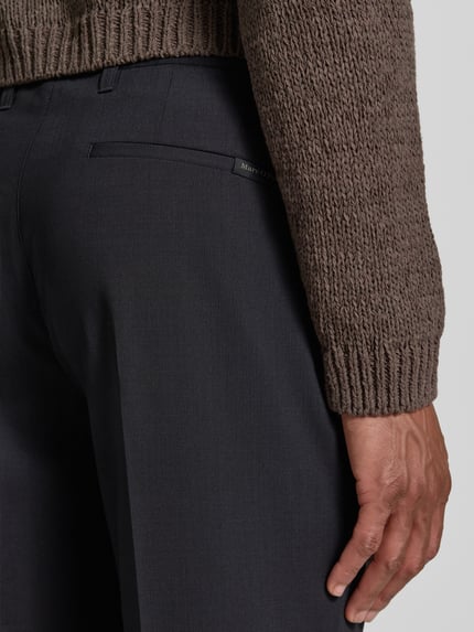 Männermodel trägt Tapered Fit Weite Hose 'MOROT JOGGER' - Marc O'Polo × DFB Travel Collection aus dunkelgrauem Stoff, Detailaufnahme, Herren Weite Hose von Marc O'Polo.