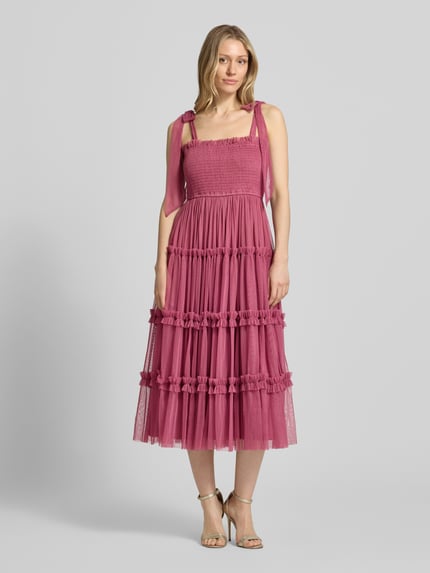 Frauenmodel trägt Knielanges Cocktailkleid mit Smok-Details von LACE & BEADS in A-Linie aus Mesh im Stufen-Look, kräftiges Pink, Ganzkörperansicht von vorne.