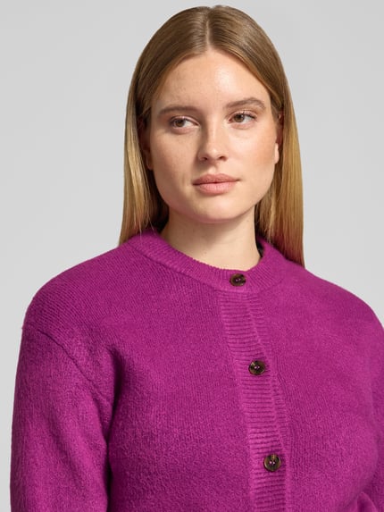 Frauenmodel trägt Cardigan mit Knopfleiste von Jake*s Casual in kräftigem Pink mit Struktur-Strick, Rundhals, langarm, Nahaufnahme Oberkörper.
