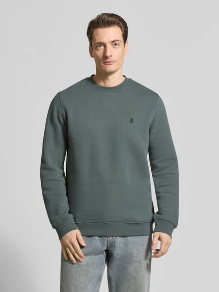 Männermodel trägt Regular Fit Sweatshirt aus reiner Bio Baumwolle Modell 'BAARO FLEECE' von Armedangels, Optik: Unifarben, Logo-Detail, Rundhals, Langarm, Rippbündchen, Materialverarbeitung: Sweat, Ganzkörperansicht von vorne.