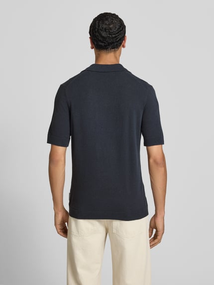Männermodel trägt dunkelblaues Regular Fit Poloshirt aus Baumwoll-Mix von Marc O'Polo Denim, strukturierte Oberfläche, Ganzkörperansicht Rückansicht.