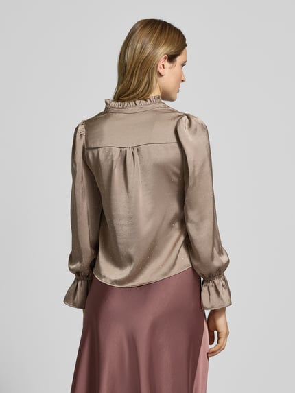 Frauenmodel trägt Relaxed Fit Bluse mit Tunika-Kragen Modell 'Amara' von Neo Noir, Elastischer-Material-Mix, Rüschenbesatz, Langärmelig, Rückenlänge 55 cm, Ärmelabschluss mit Rüschenbesatz, Unifarbener Look in Naturtönen, fließende Textur, Ganzkörperansicht Rückansicht.