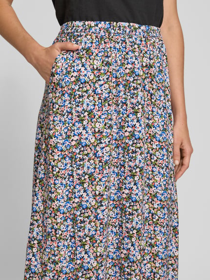 Frauenmodel trägt Ausgestellter Maxi-Rock aus reiner Viskose Modell 'EASY JOY' von Vero Moda im grafischen Allover-Muster, Nahaufnahme Oberkörper.