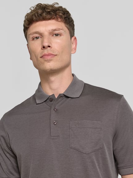 Männermodel trägt Regular Fit Poloshirt mit Brusttasche und Label-Stitching von bugatti in Grau, feine Struktur, Nahaufnahme Oberkörper.