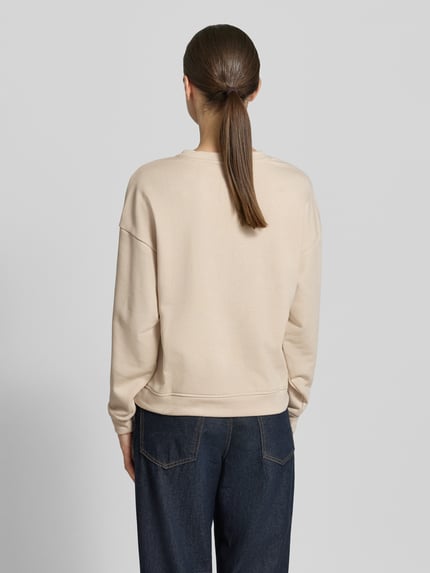 Frauenmodel trägt Sweatshirt mit Label-Stitching Modell 'Mela Briena' von MSCH Copenhagen aus Baumwoll-Mix in Loose-Fit, Ganzkörperansicht Rückansicht.