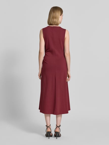 Frauenmodel trägt Tailliertes Freizeitkleid aus Baumwoll-Mix von s.Oliver RED LABEL, Farbe Bordeaux, Optik: Unifarben, Midi-Länge, Ganzkörperansicht Rückansicht.