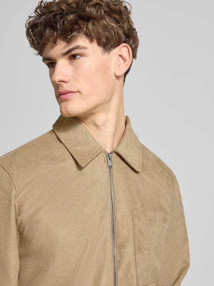Männermodel trägt Regular Fit Jacke in Lederoptik Modell 'RICK' von Only & Sons in Beige, Umlegekragen, Reißverschluss, Nahaufnahme Oberkörper.