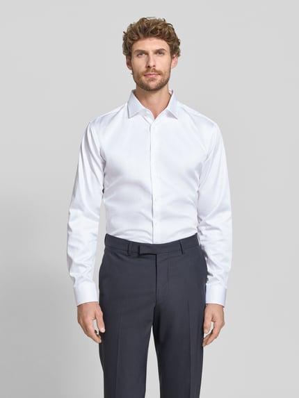 Männermodel trägt Regular Fit Businesshemd aus reiner Baumwolle von Seidensticker, weiß, Kentkragen, Knopfleiste, Ganzkörperansicht von vorne. Rückenlänge 74 cm, Schulterbreite 44 cm, Ärmellänge 66 cm.