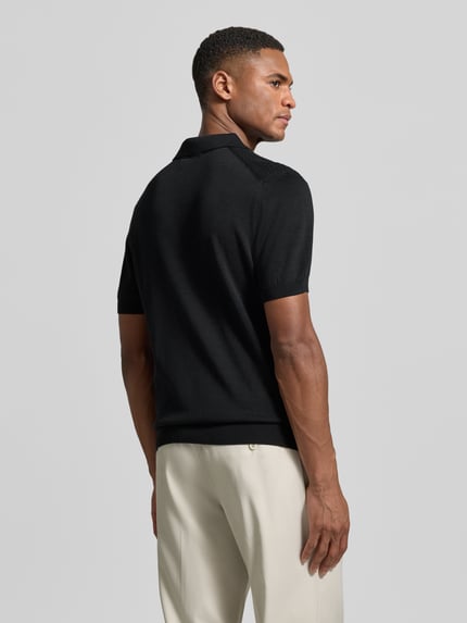 Männermodel trägt Regular Fit Poloshirt aus reiner Baumwolle von Strellson in Schwarz, Feinstrick, Strickoptik, Strukturmuster, Ganzkörperansicht Rückansicht.