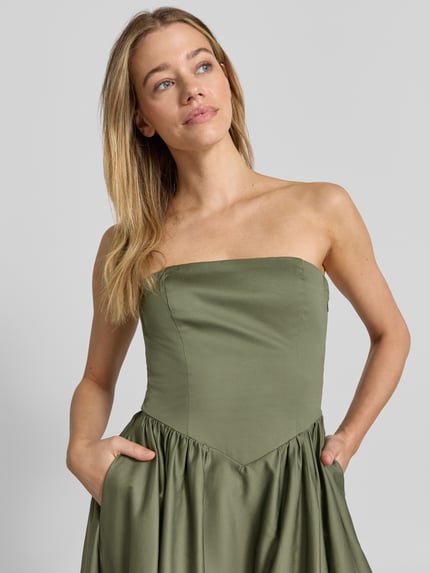 Frauenmodel trägt Cocktailkleid im Off-Shoulder-Look mit Smok-Details von Jake*s Cocktail aus Baumwoll-Elasthan-Mix, Nahaufnahme Oberkörper.