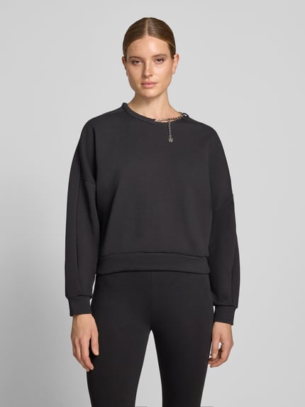 Vrouwenmodel draagt zwart boxy fit sweatshirt van katoenmix model 'Denrietta' van HUGO, Dames sweatshirt, vooraanzicht heuphoogte