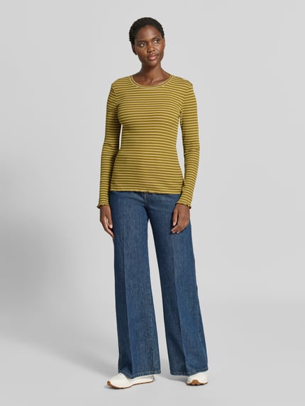 Frauenmodel trägt Slim Fit Langarmshirt aus Baumwoll-Mix Modell 'ANNA' von Selected, gelb-schwarz gestreift, Damen Langarmshirt, Ganzkörperansicht von vorne.