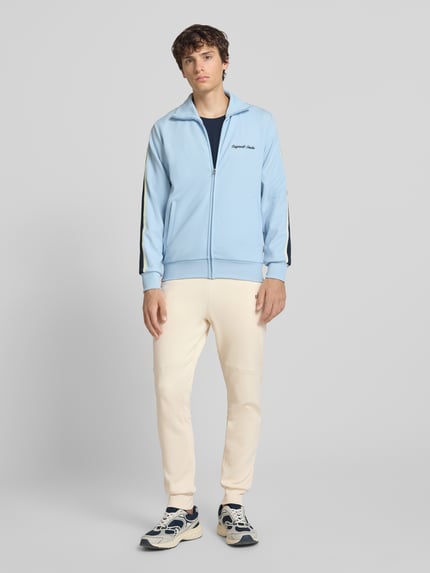 Männermodel trägt Regular Fit Sweatpants mit Label-Applikation von Balr., cremefarben, Baumwoll-Mix, Ganzkörperansicht von vorne.