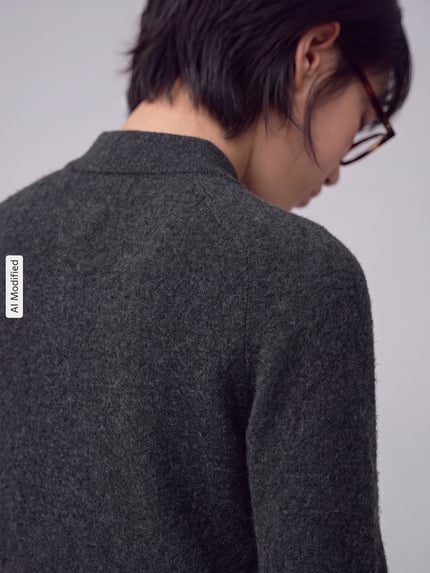 Vrouwenmodel draagt Strickpullover aus Schurwoll-Kaschmir-Mix Modell 'CELLULA' van MM by Max Mara, zachte grijze stof, detailopname van achteren, regular fit, polokraag, knoopsluiting, ruglengte 56 cm, mouwlengte 63 cm, KI-gemodificeerd beeld.
