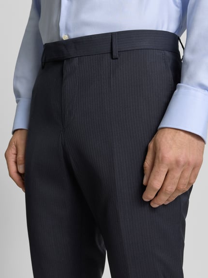 Männermodel trägt Regular Fit Anzughose aus reiner Schurwolle Modell 'H-GENIUS-263' von BOSS, dunkelblau, Nadelstreifen-Muster, Nahaufnahme Oberkörper.