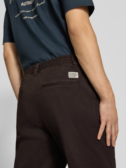 Mannenmodel draagt Barrel Fit broek van katoenmix van Marc O'Polo DENIM in donkerbruin, detailopname rugaanzicht
