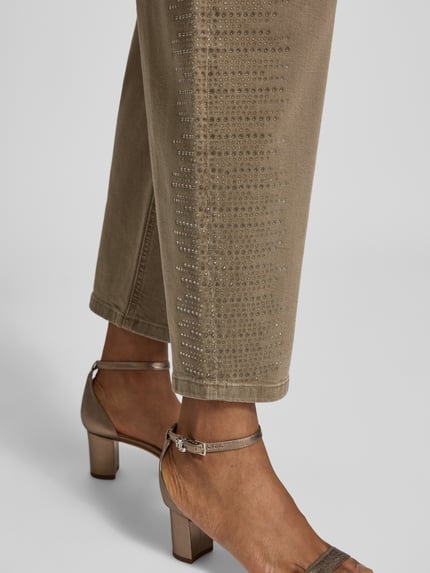 Vrouwenmodel draagt Jeans aus Baumwoll-Mix mit Strasssteinbesatz van Liu Jo White in beige, 5-pocketmodel, met strass-steentjes, detailopname onderbeen. Dames jeans van katoenmix met los model, knoop- en ritssluiting, bandwijdte maat 27: 38 cm, binnenbeenlengte maat 27: 72 cm.