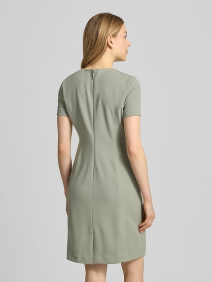 Frauenmodel trägt knielanges Etuikleid mit Rundhalsausschnitt von Calvin Klein, gerade Form, stretchiger Material-Mix, Rückansicht Ganzkörperansicht.